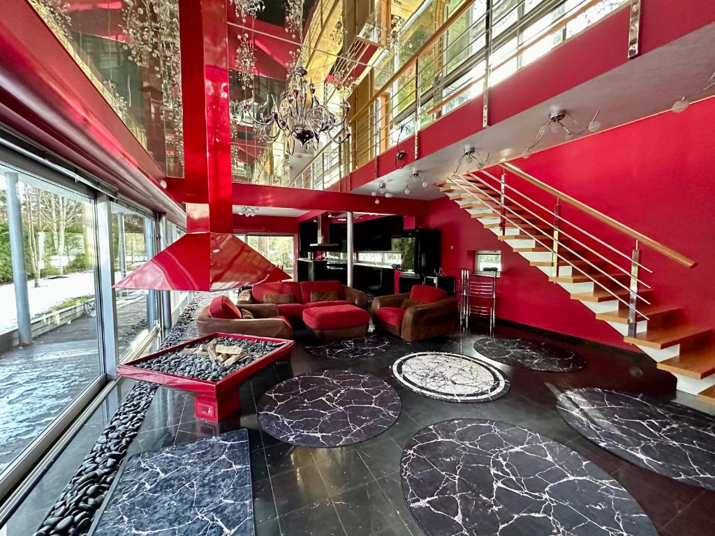 a living room with red walls and a staircase at Merirahu private luxury villa in Tallinn