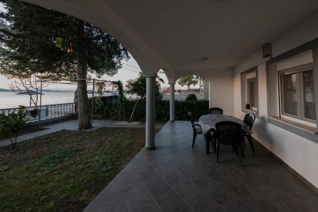 une terrasse avec une table et des chaises et l'océan dans l'établissement Bibinje Apartments, à Bibinje