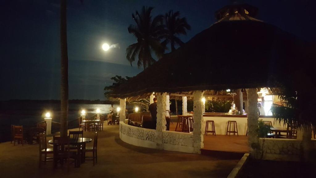 a building with a table and chairs at night at Southern Cross Hotel Mtwara in Mtwara