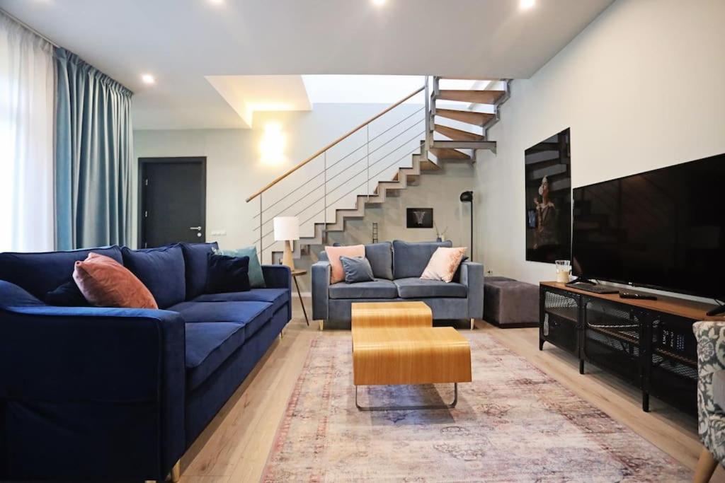 un soggiorno con divani blu e TV di Moft Loft. Lovely, comfy apartment. a Cluj-Napoca