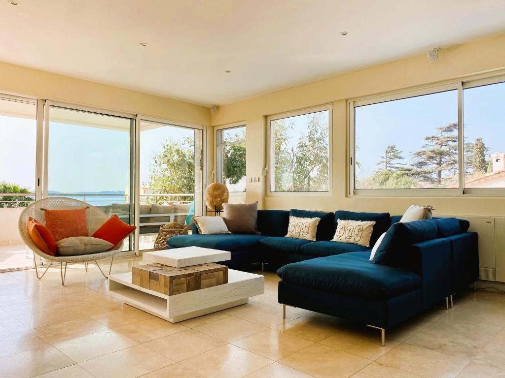 uma sala de estar com um sofá azul e uma mesa em Villa Montfleuri, vieille ville à pieds, vue mer, piscine, 8 pers em Sainte-Maxime