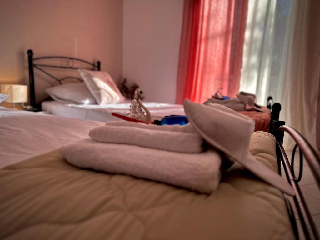 a bedroom with two beds and towels on a bed at Katerina Apartments in Lefkimmi