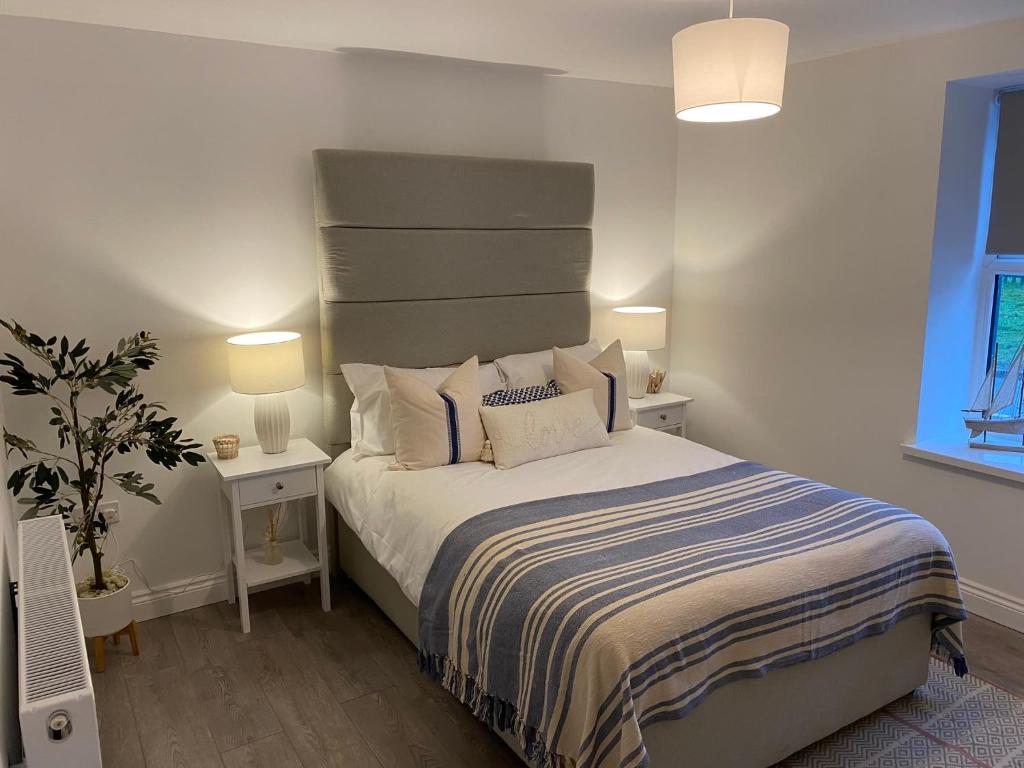 1 dormitorio con 1 cama, 2 mesas y 2 lámparas en Forest Cwtch by Afan Valley Escapes, en Port Talbot