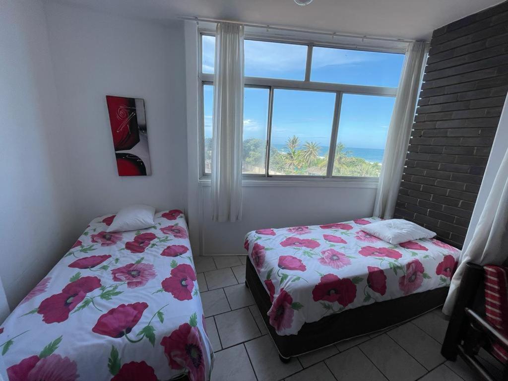 a bedroom with two beds in front of a window at Amanzimtoti Beachfront Holiday Apartment , Flat No 23, Ezulweni in Durban