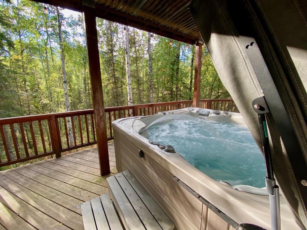 uma banheira de hidromassagem no deque de uma cabina em Guest Suite with Hot Tub - Edge of the Wild em Eagle River