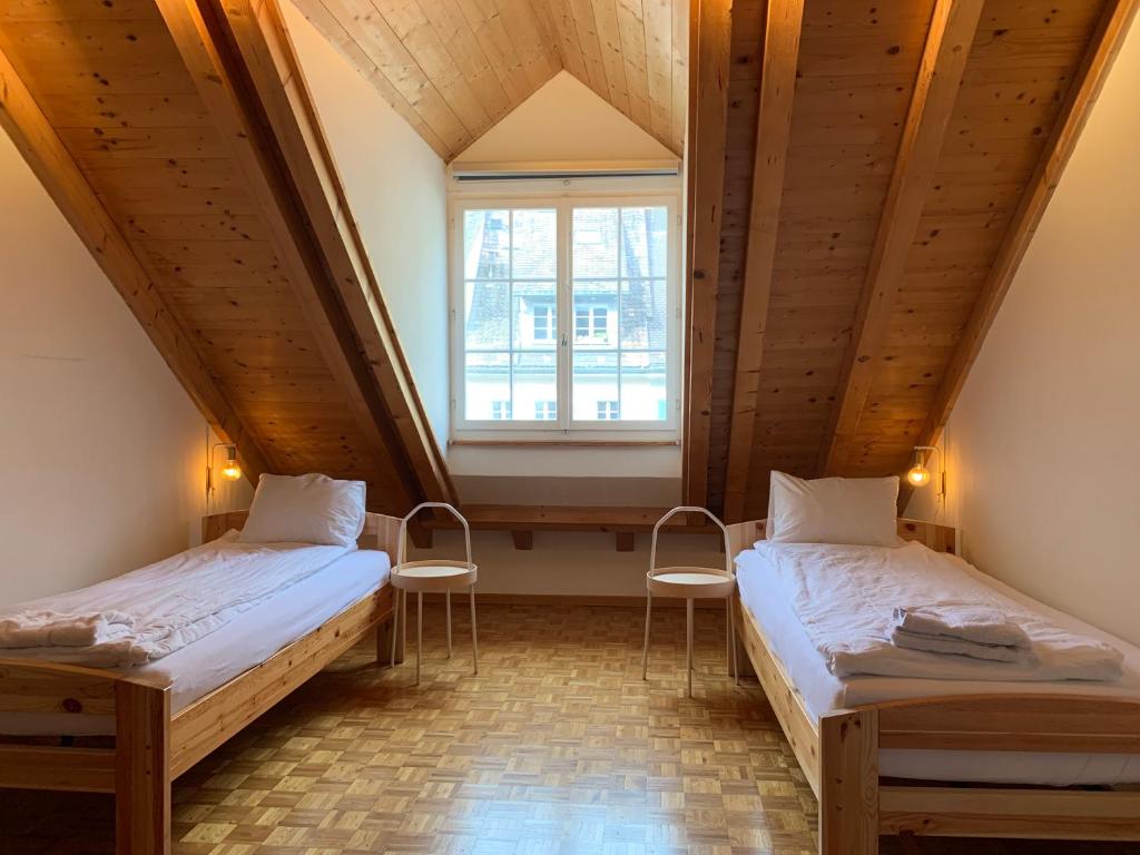 Duas camas num quarto com uma janela grande em Old Town Loft & Central Location in Rapperswil em Rapperswil-Jona