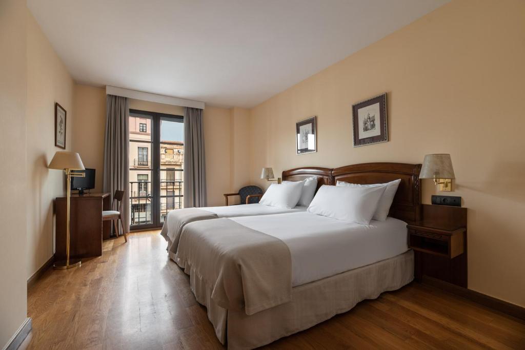 Habitación de hotel con cama grande y ventana en Exe Astur Plaza, en Astorga