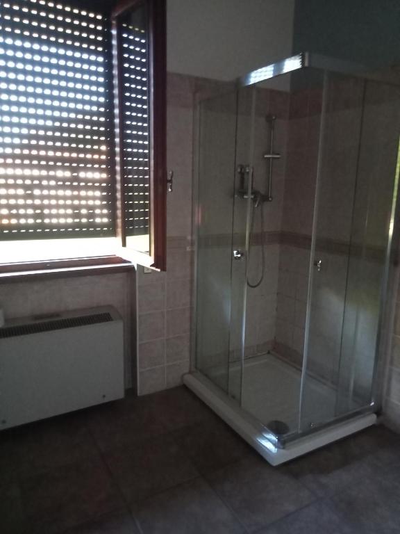uma casa de banho com um chuveiro e uma cabina de duche em vidro. em patrizia em Gravellona Toce