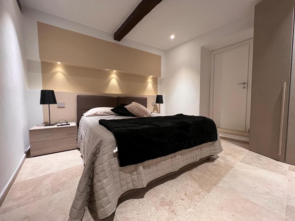 a bedroom with a bed with a black blanket on it at Mia Margot Suite Apartment in Castagneto Carducci