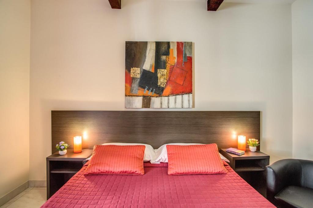 a bedroom with a red bed with two orange pillows at Hotel Mosaic in Rome