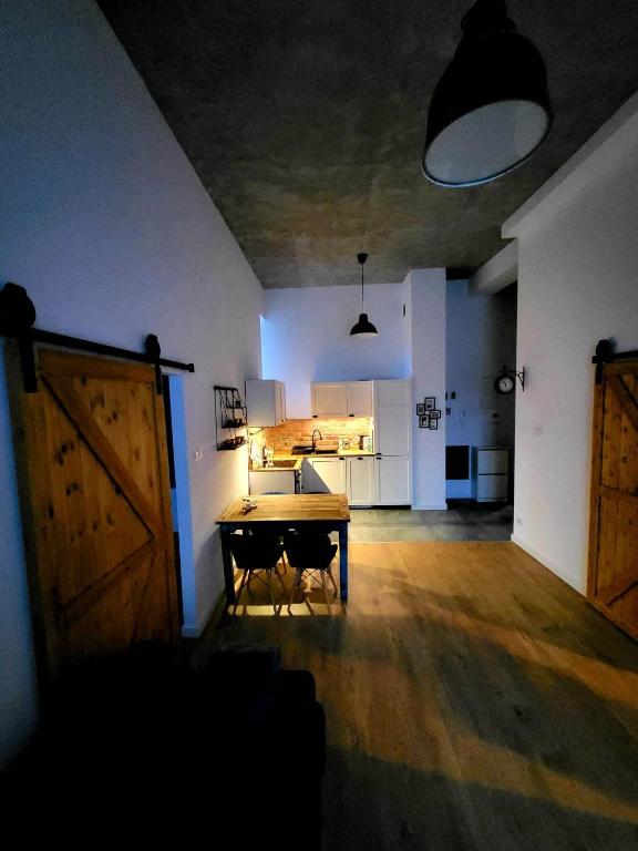 ein leeres Zimmer mit einem Tisch und einer Küche in der Unterkunft Tatarska Sen Apartamenty in Przemyśl