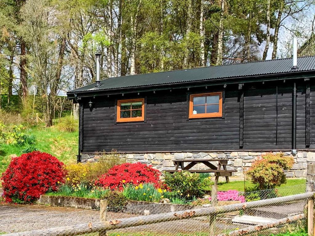 uma cabine preta com um banco à frente em Squirrel View em Newtonmore