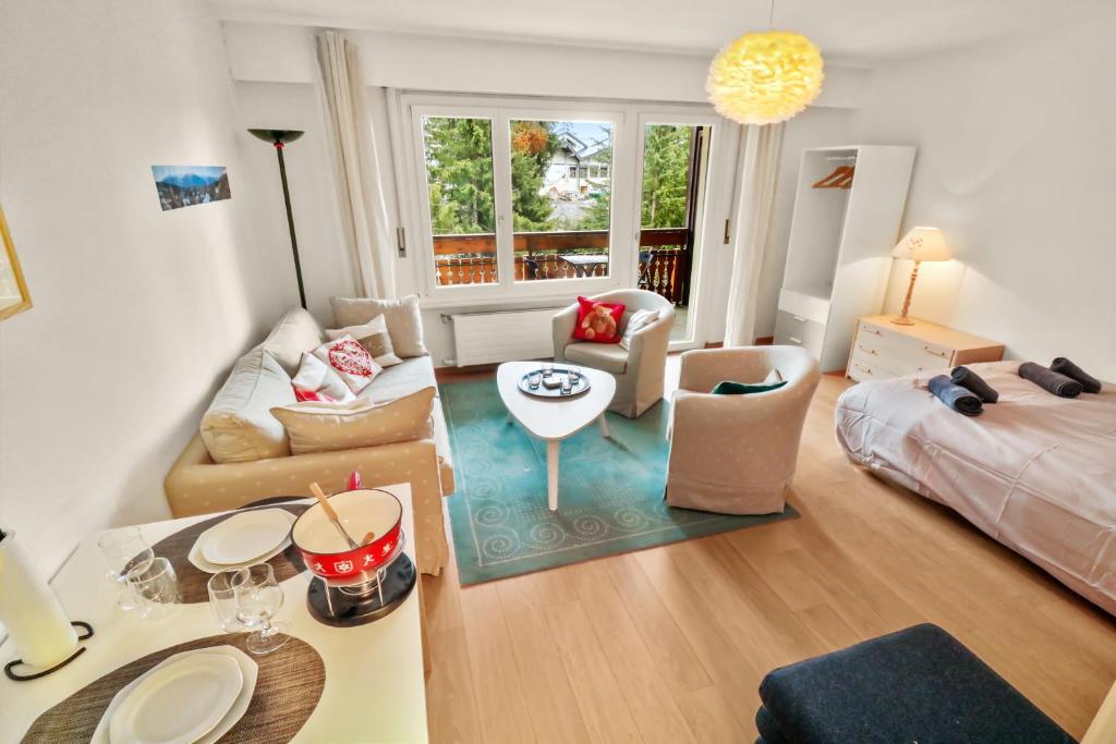 ein Wohnzimmer mit einem Sofa und einem Tisch in der Unterkunft Studio chaleureux et paisible in Lens