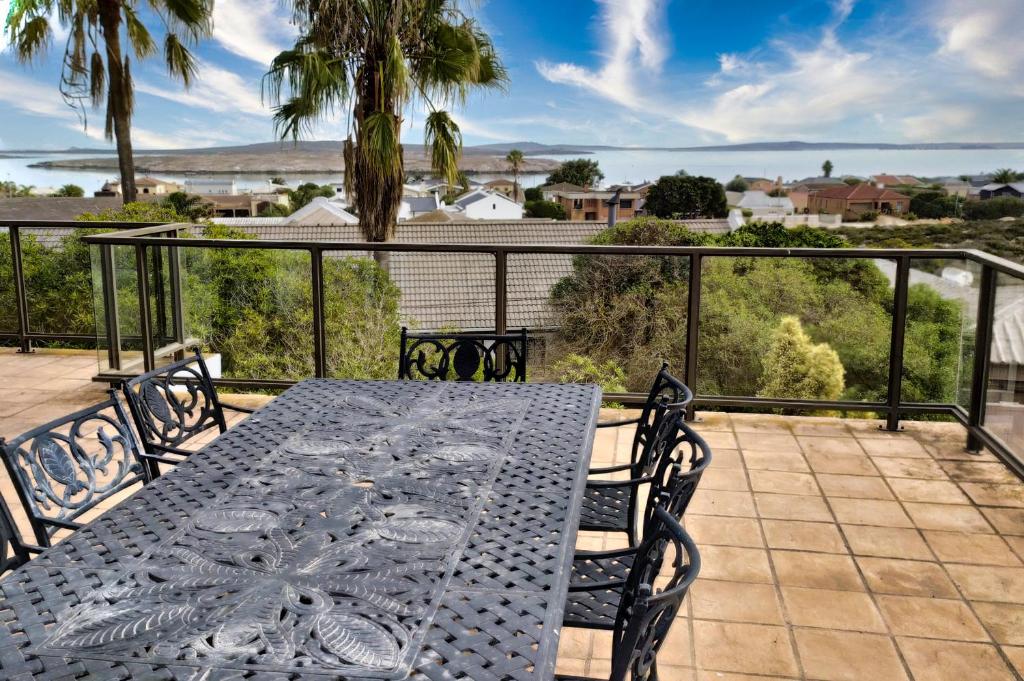 a table on a balcony with a view of the ocean at Galico Holiday Home in Langebaan