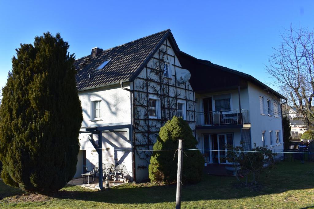 a large white house with a black roof at Ferienwohnung Saaleblick in Schwarzenbach an der Saale
