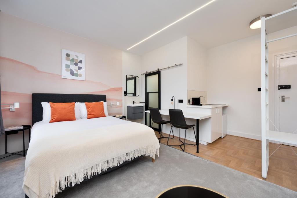 - une chambre avec un grand lit et un bureau dans l'établissement D8 House, à Londres