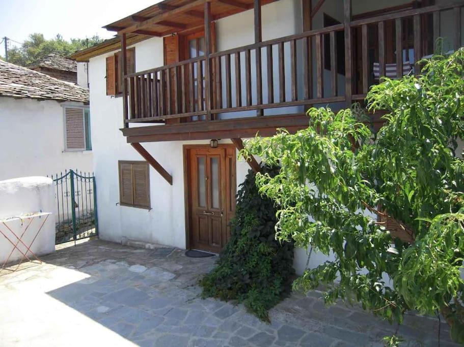a house with a wooden door and a balcony at ΠΑΝΑΓΙΑ ΠΑΡΑΔΟΣΙΑΚΟ ΣΠΙΤΙ in Panayia
