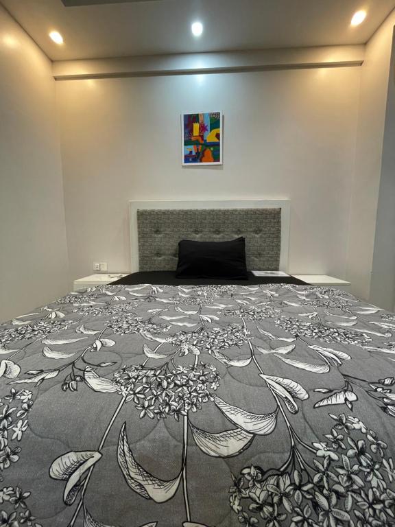 a bedroom with a bed with a black and white blanket at SUPER STAY NEX in Noida
