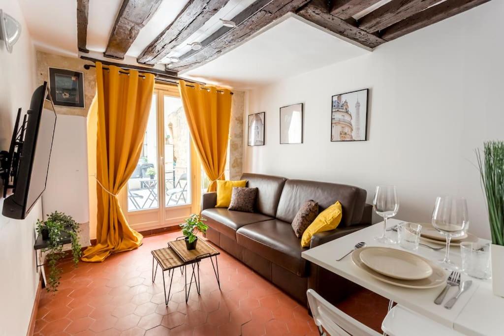 uma sala de estar com um sofá e uma mesa em Sweety home in center of Paris em Paris