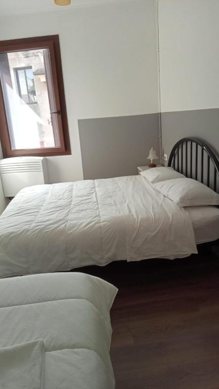 2 białe łóżka w sypialni z oknem w obiekcie Casa Belzoni w Padwie