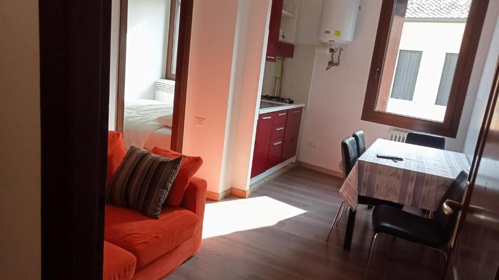 salon z czerwoną kanapą i stołem w obiekcie Casa Belzoni w Padwie
