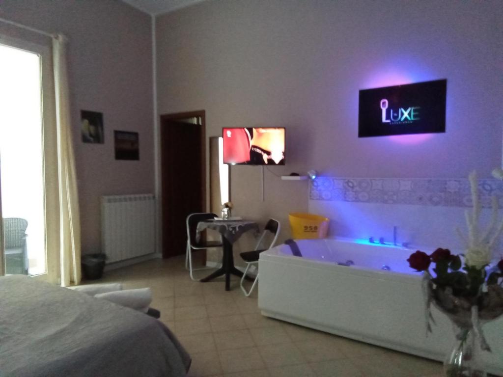 1 dormitorio con bañera y una señal de amor en la pared en Vida Rooms Luxury, en Palermo