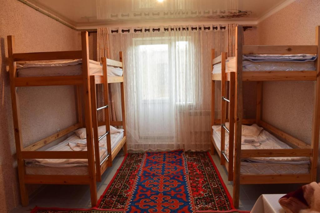 a room with four bunk beds and a rug at Naryn Guest House in Naryn