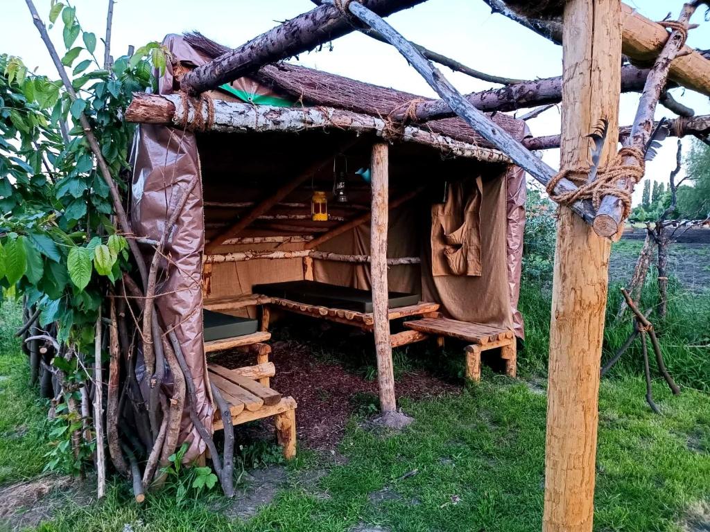 ein Blockhaus mit einer Bank im Gras in der Unterkunft Au Pied Du Trieu, The Shelter in Labroye