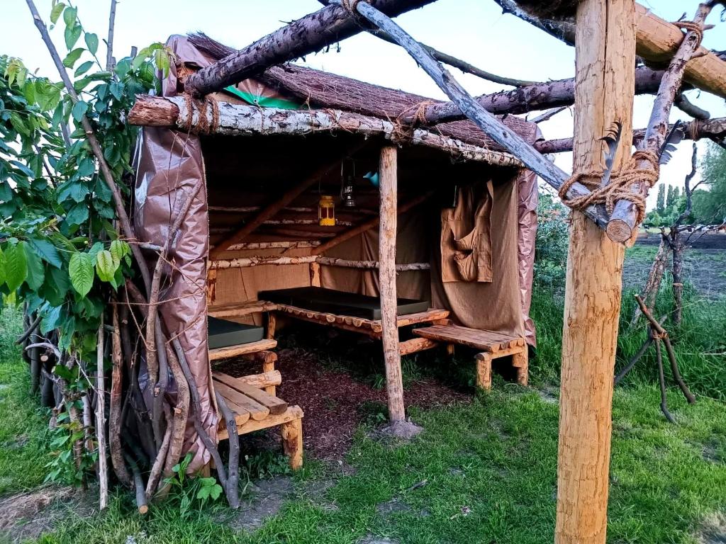 una cabaña de madera con un banco en el césped en Au Pied Du Trieu, The Shelter, en Labroye