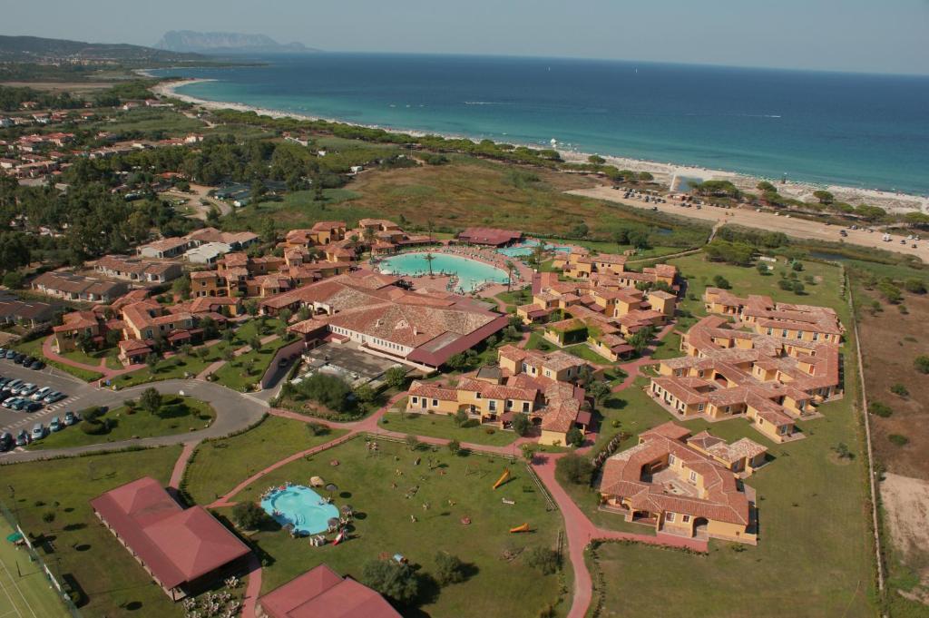an aerial view of a resort with a pool and the ocean at Valtur Baia dei Pini in Budoni