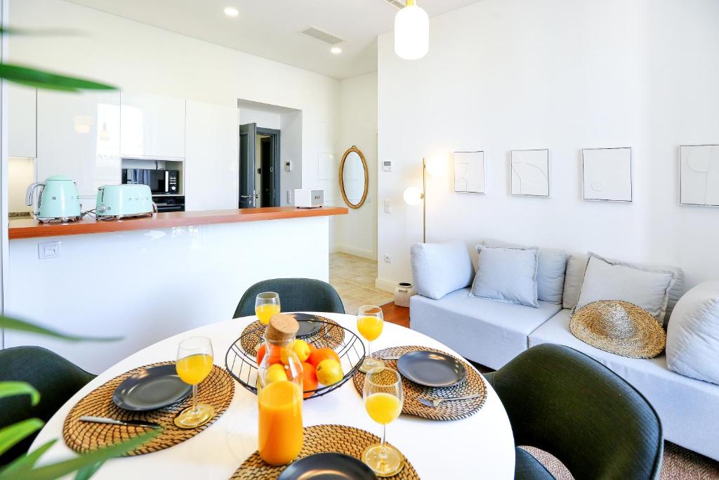 a dining room with a white table with glasses of orange juice at Offline Mood Apartment in Faro