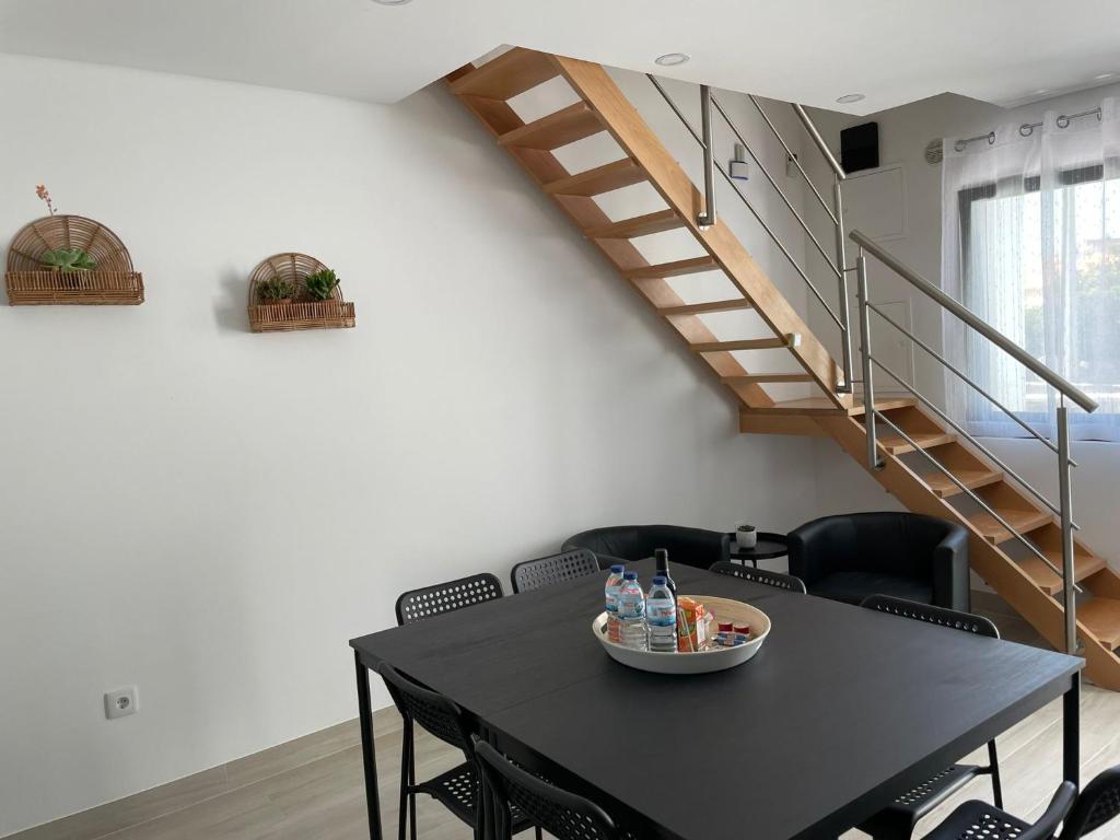 a black table and chairs in a room with a staircase at Porto Smart Apartments Comfort in Perafita