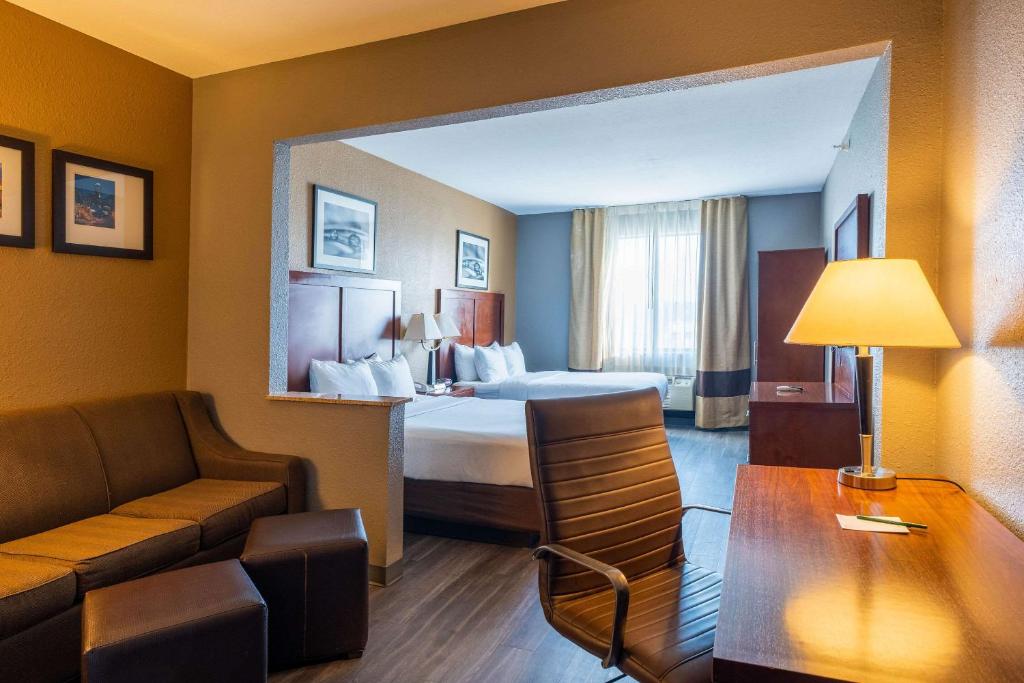 une chambre d'hôtel avec un lit et un canapé dans l'établissement Quality Suites NE Indianapolis Fishers, à Fishers