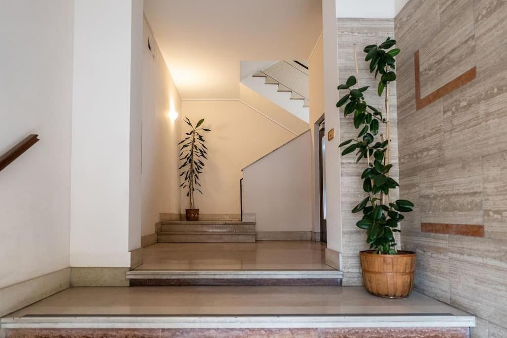 a hallway with stairs and potted plants at Casa Alessia Appartamento Confortevole in Gassino Torinese
