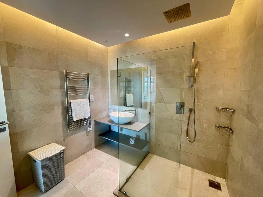 a bathroom with a glass shower and a sink at City View Apartment Nestled in the Heart of NBO in Nairobi