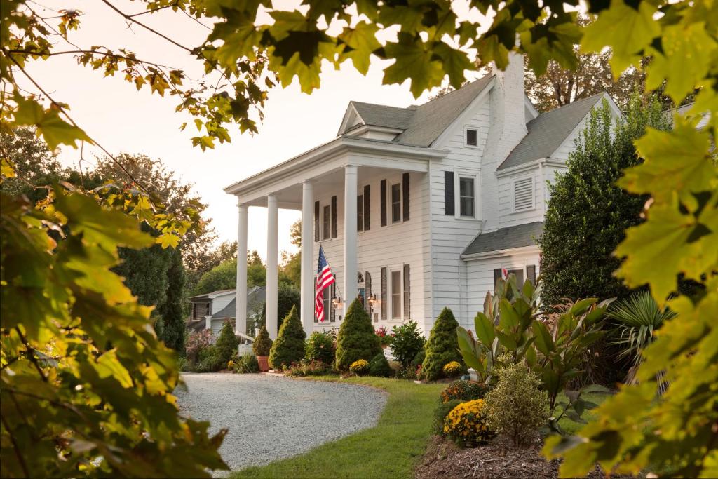 a white house with an american flag on it at Arrowhead Inn in Durham