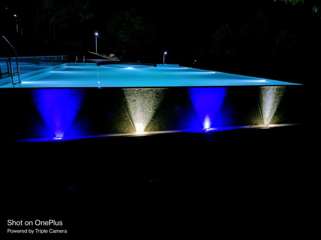 una piscina por la noche con luces azules en Grand Ambience Resort, en Diveagar