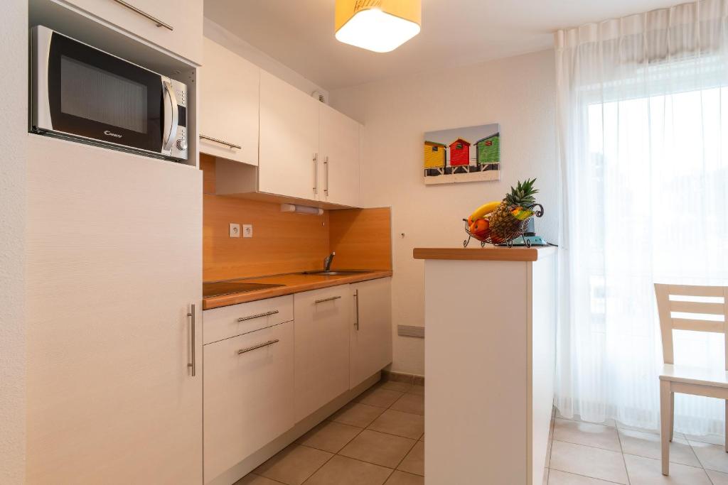 Kuchyň nebo kuchyňský kout v ubytování L'Arvor - Appt piscine et sauna partagés