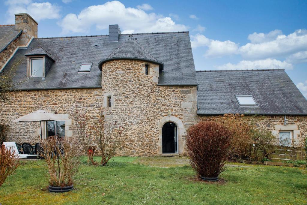 duży ceglany dom z szarym dachem w obiekcie Tour des Alleux - Maison de maître pour 6 w mieście Taden