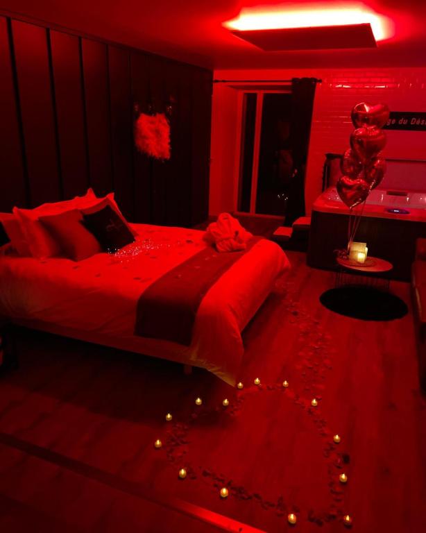 un dormitorio rojo con una cama con luces. en L'Evasion chambre MONTMARTRE avec Jacuzzi privatif en Prinquiau