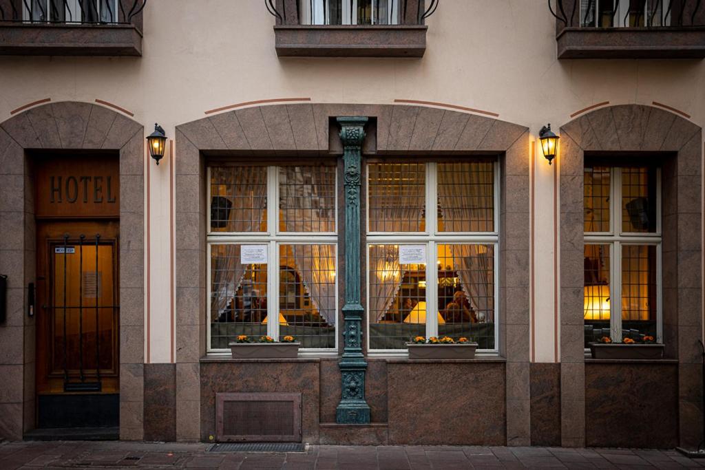 un edificio con tres ventanas con luces. en Nostalgie Altstadt Hotel Kornpforte by 42 en Koblenz