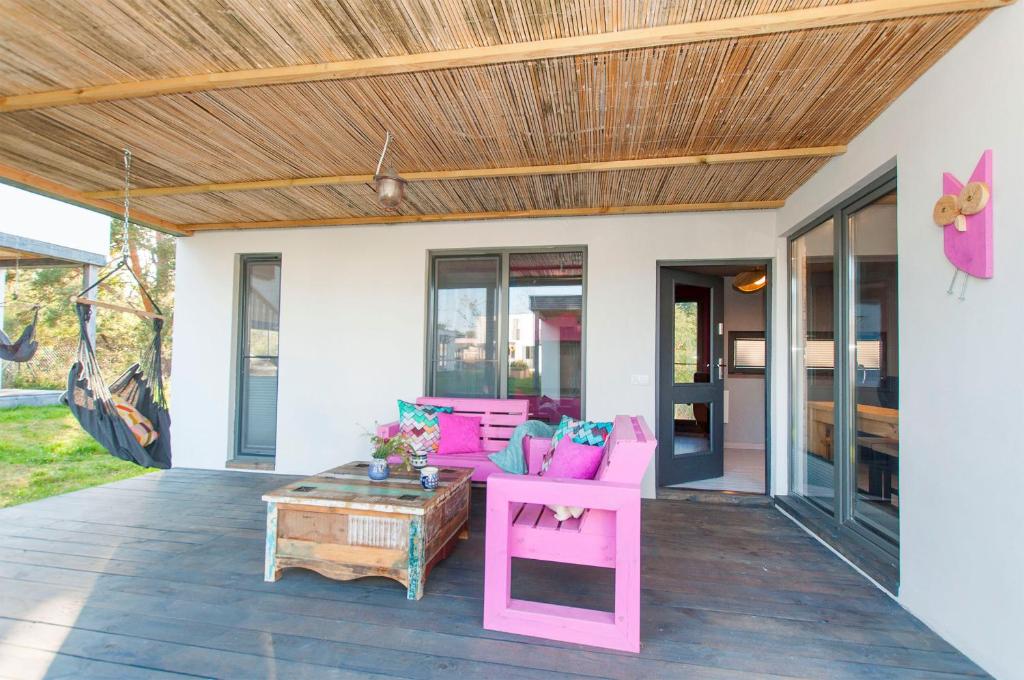 a patio with pink furniture and a wooden ceiling at Sobieszepty, odetchnij ciszą in Gdańsk