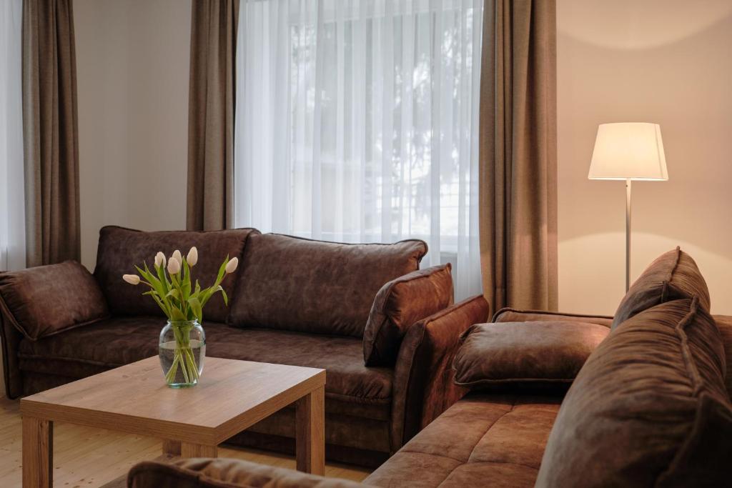 uma sala de estar com um sofá e uma mesa em Jonavos alpakų svečių namai em Jonava