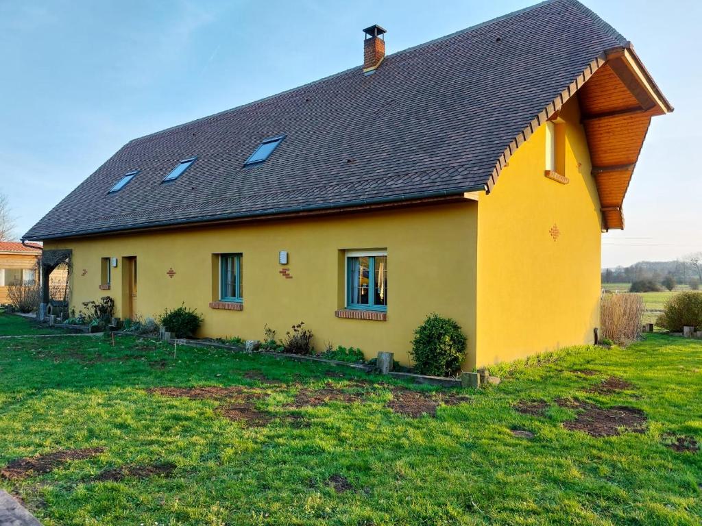 ein gelbes Haus mit schwarzem Dach in der Unterkunft Maison de 4 chambres avec jardin clos et wifi a Roncherolles en Bray in Mauquenchy