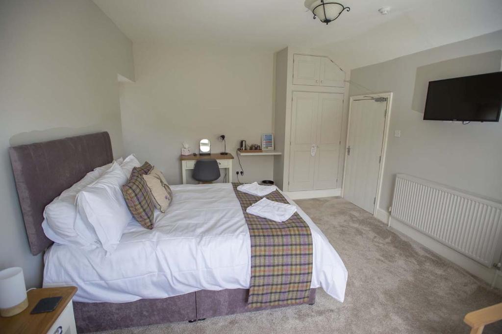 a bedroom with a bed with a tv on the wall at The Berwyn Arms in Corwen