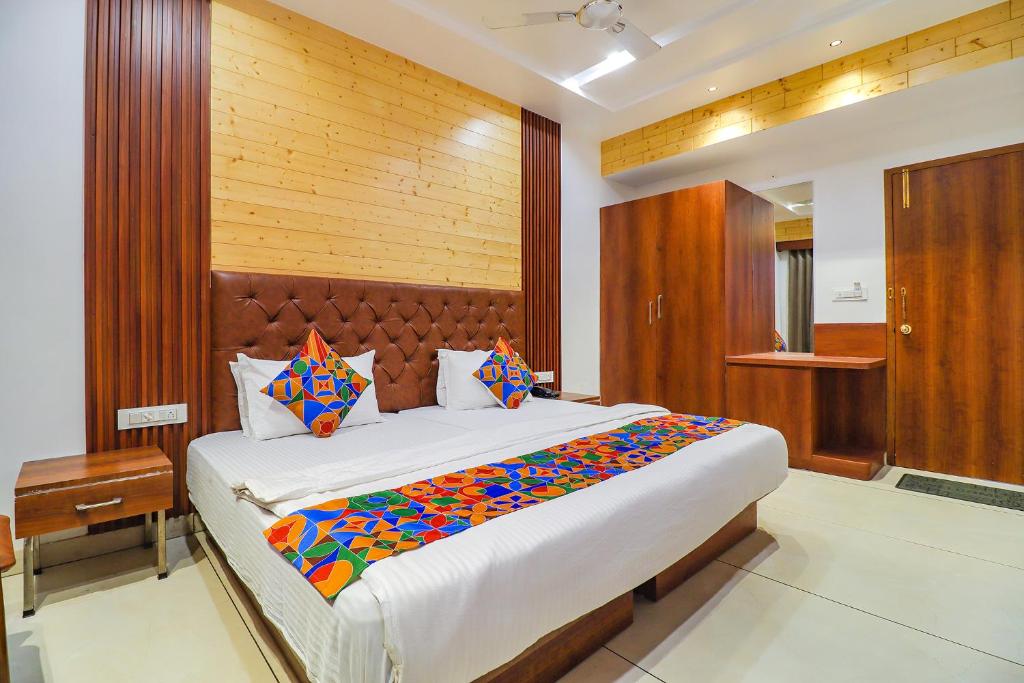 a bedroom with a large bed with colorful sheets at FabHotel Grand Arya in Patna