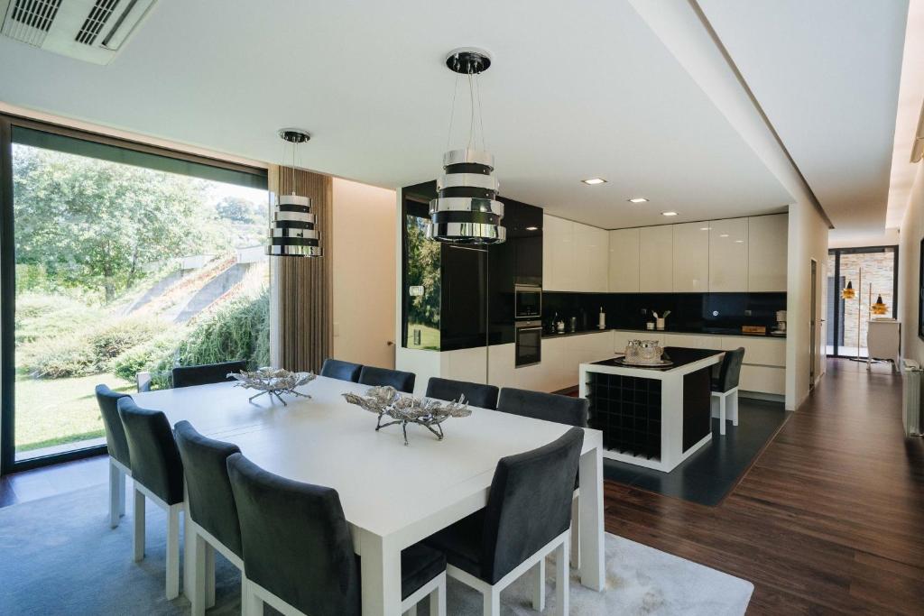 eine Küche und ein Esszimmer mit einem weißen Tisch und Stühlen in der Unterkunft Quinta do Pomar Maior in Arouca