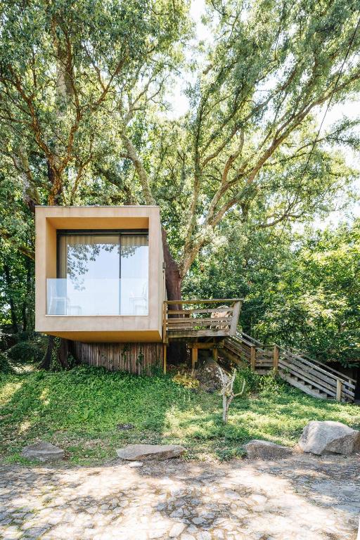a house built around a tree with a window at Quinta do Pomar Maior in Arouca