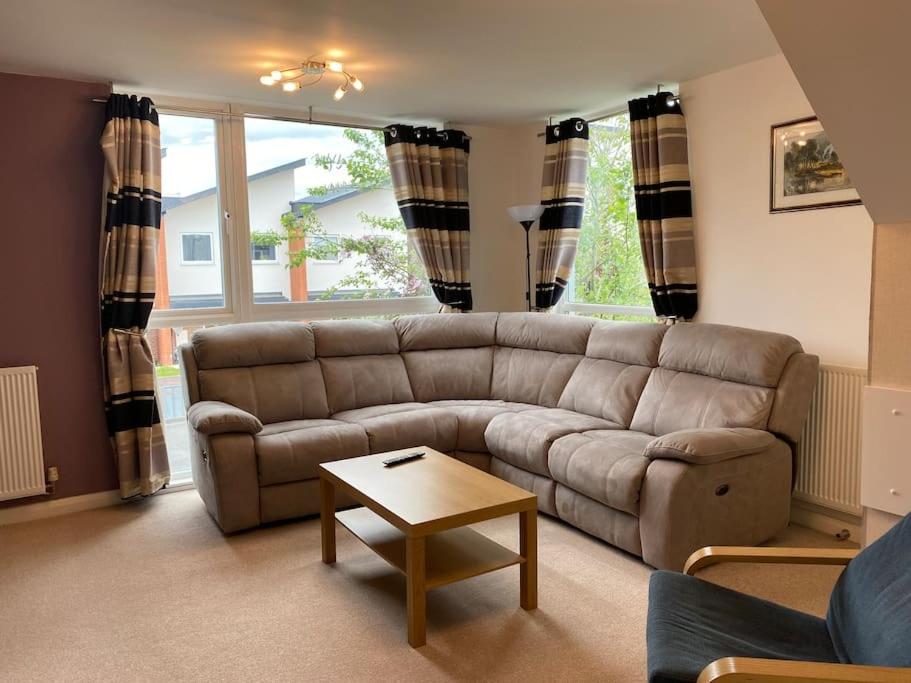 Comfortable 3-Storey House with Free Car Parking في مانشستر: غرفة معيشة مع أريكة وطاولة قهوة