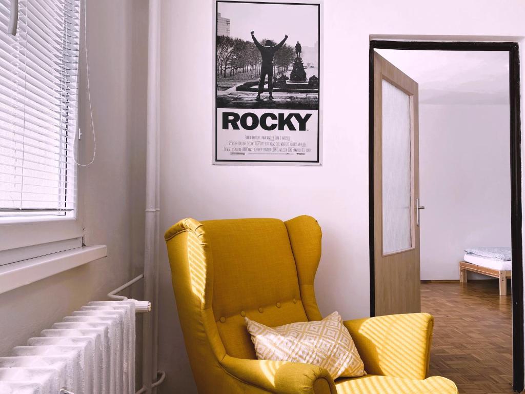 a yellow chair in a living room with a mirror at Apartman JakoDoma vlastní parkování u domu ZDARMA in Česká Lípa